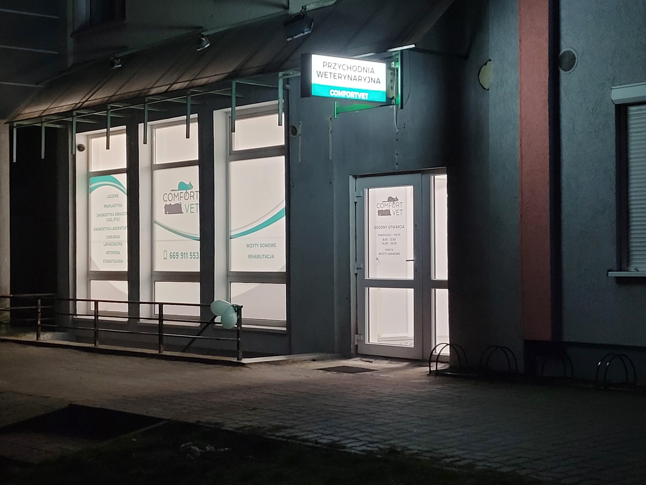 Wejście do przychodni Comfortvet z podświetlonym szyldem przy ul. Nakielskiej wieczorem